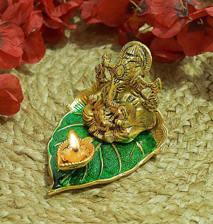 Elite Brass Metal Ganesh Ji Sitting on The Green Leave with Diya Deepak , Golden Decorative Showpiece - 9 cm  (Brass, Gold) - All Inclusive Family Treasures